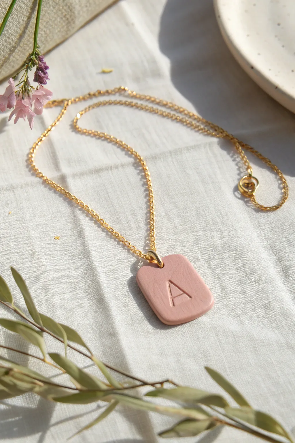 Minimal stamped initial tag necklace in soft blush polymer clay, a simple handmade gift idea