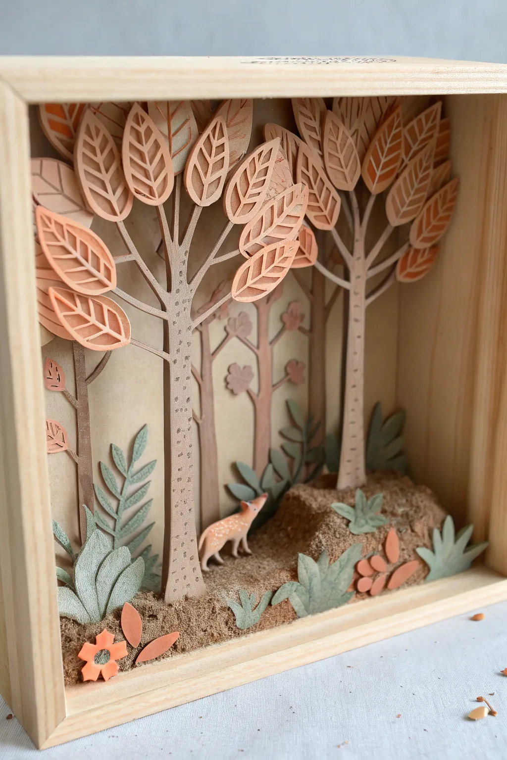 Layered forest habitat shadow box in earthy clay, calm Scandinavian lines with a boho touch.
