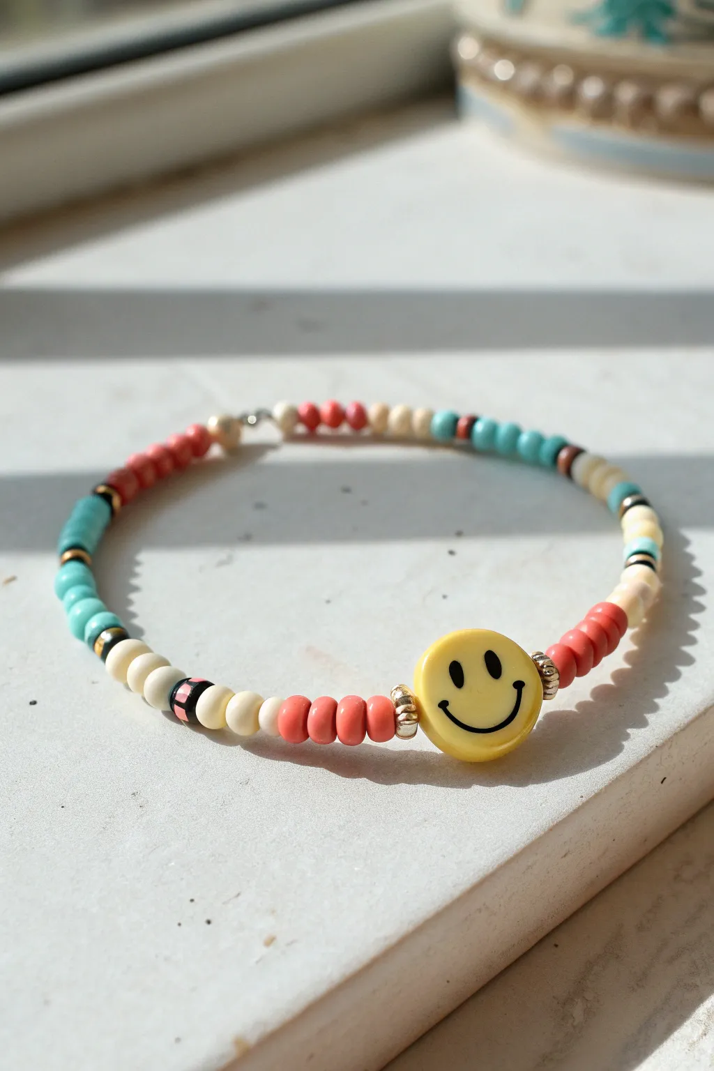 Smiley center bead bracelet with colorful heishi beads, sunny minimal flatlay inspiration.