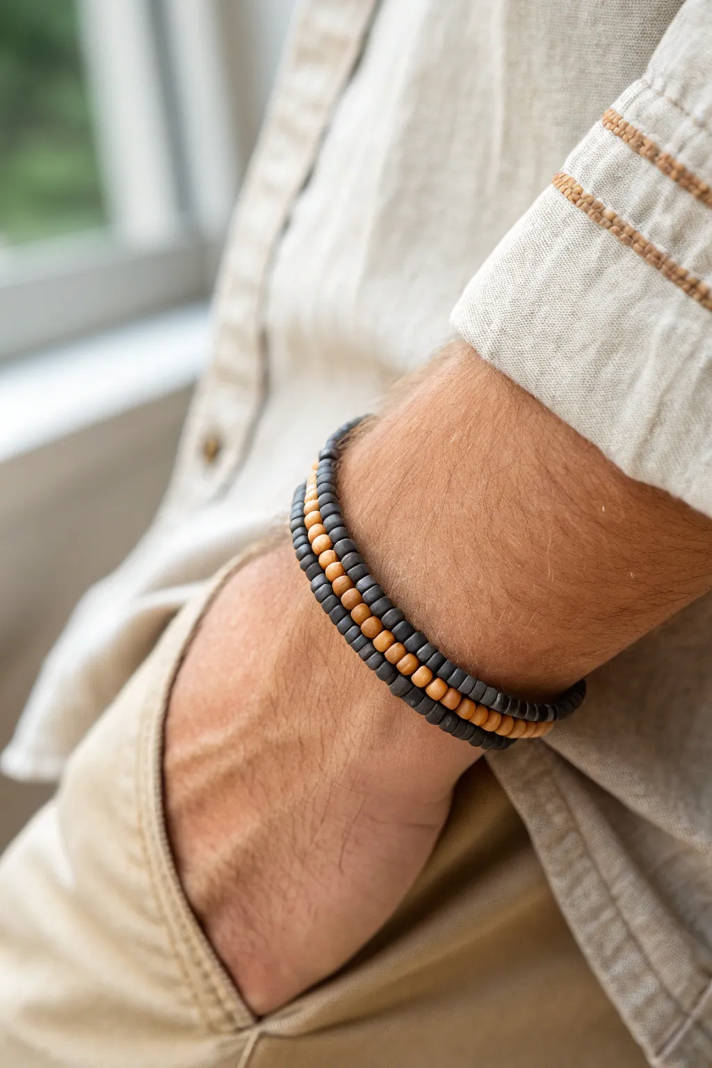 Thin clay disc beads create a flat, modern mens bracelet that looks sharp with rolled cuffs