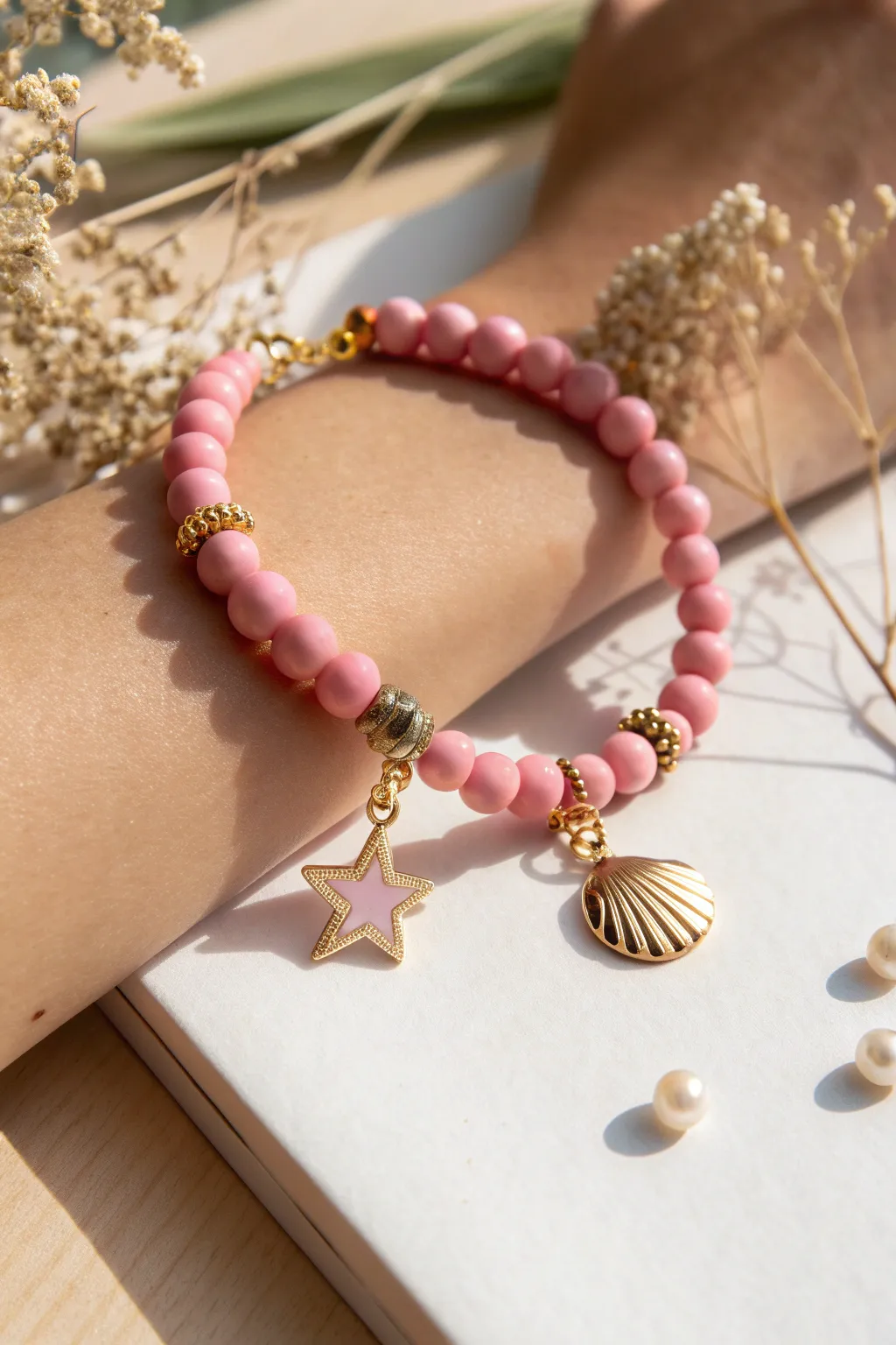 Pink charm-cluster bracelet in soft clay beads, simple Scandinavian boho elegance for everyday wear.