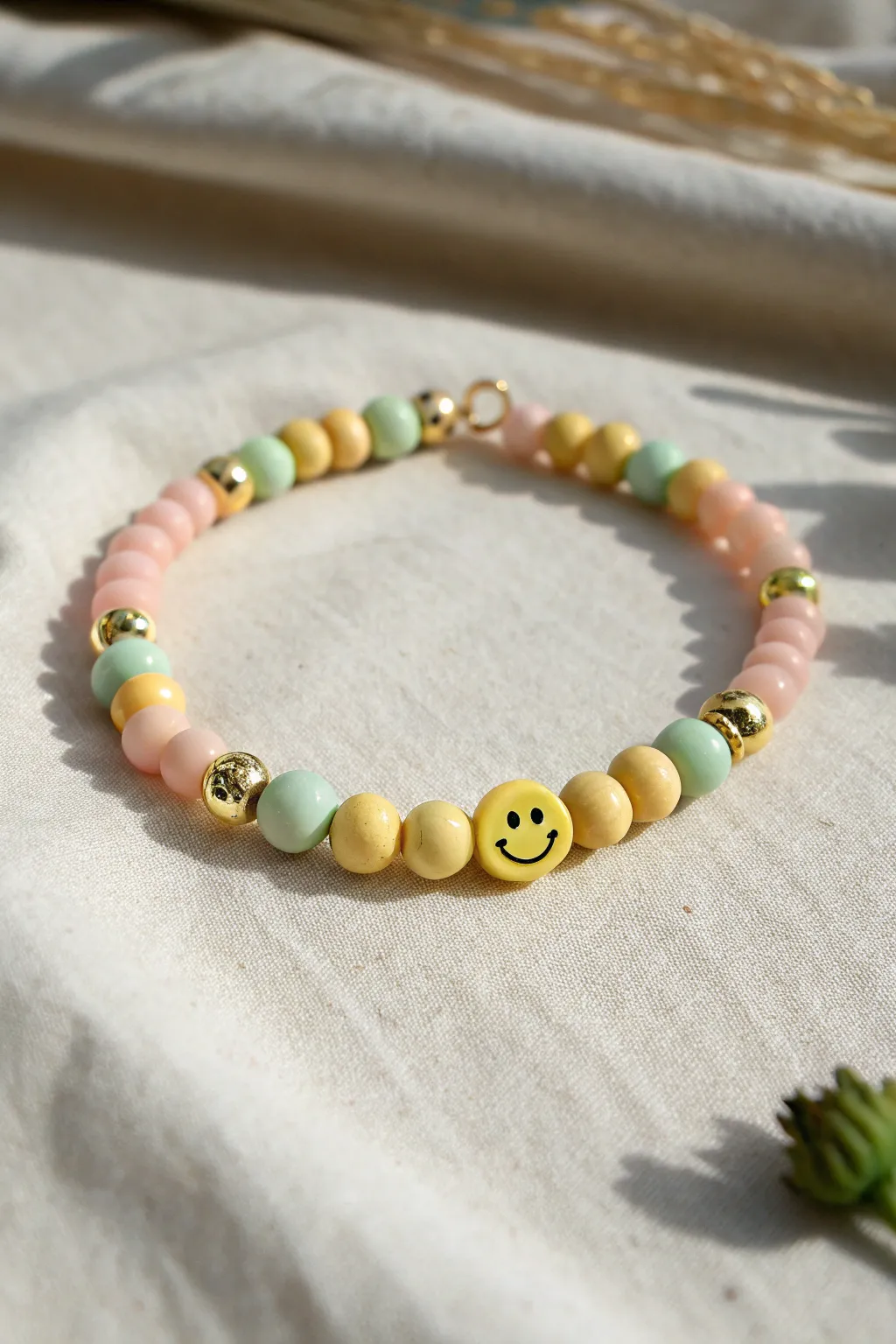 Bright heishi bracelet with smiley clay bead accents and subtle gold details for sunny vibes.