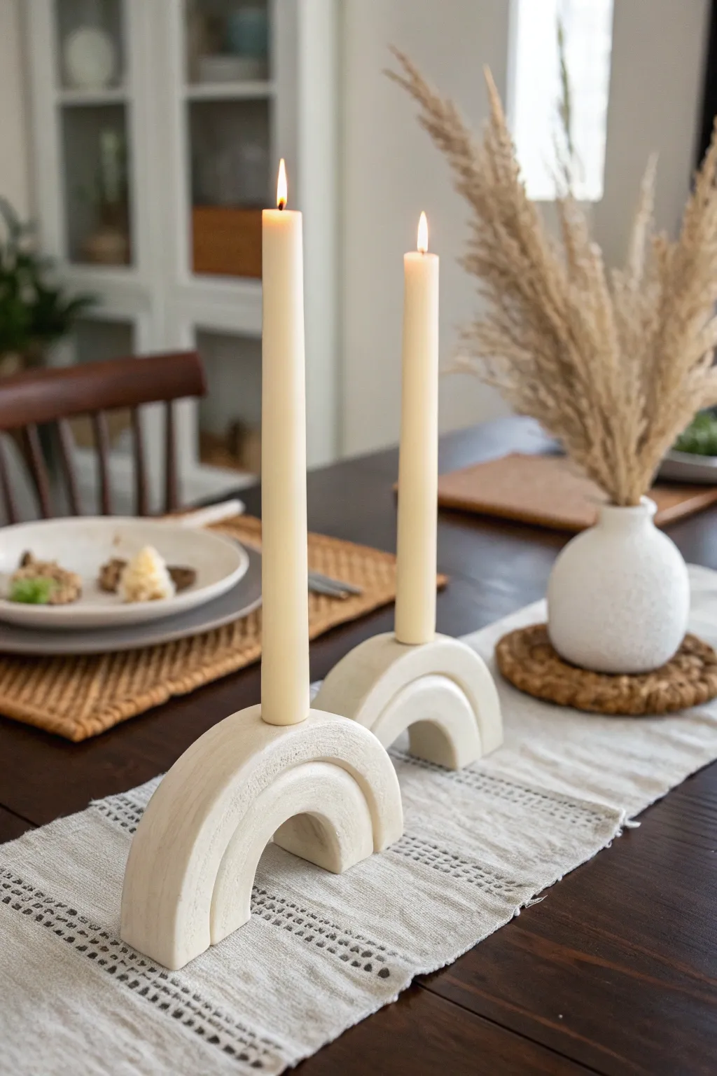 Minimal air-dry clay taper candle holders in soft neutrals for a cozy Scandinavian table