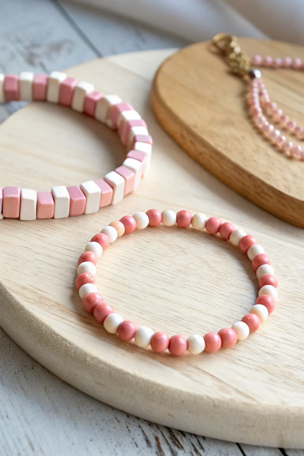 Checkerboard rhythm in blush and cream clay beads, styled with a simple solid bracelet.