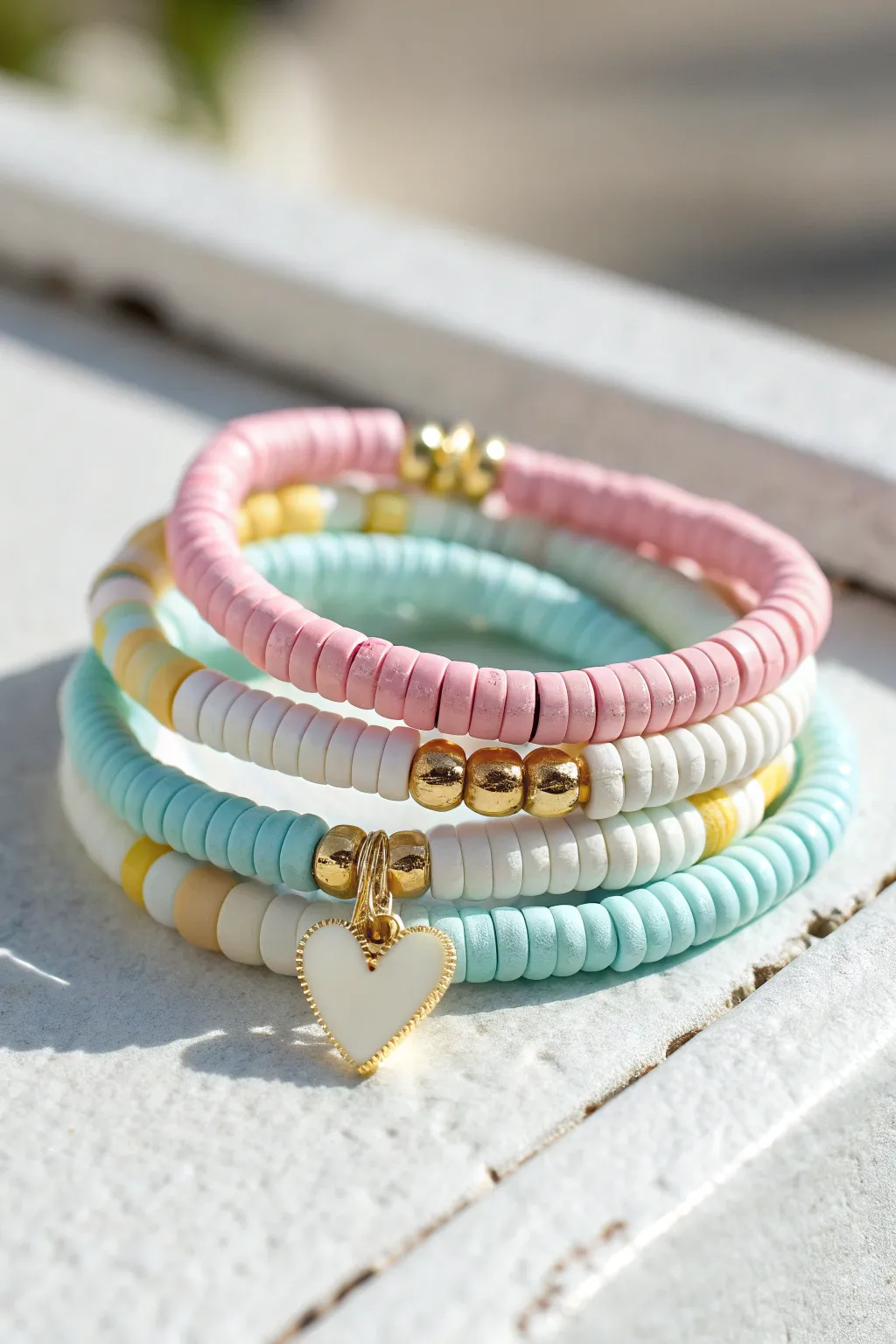 Preppy heishi bracelet stack with tiny heart centers, sunlit, minimalist, and irresistibly sweet.
