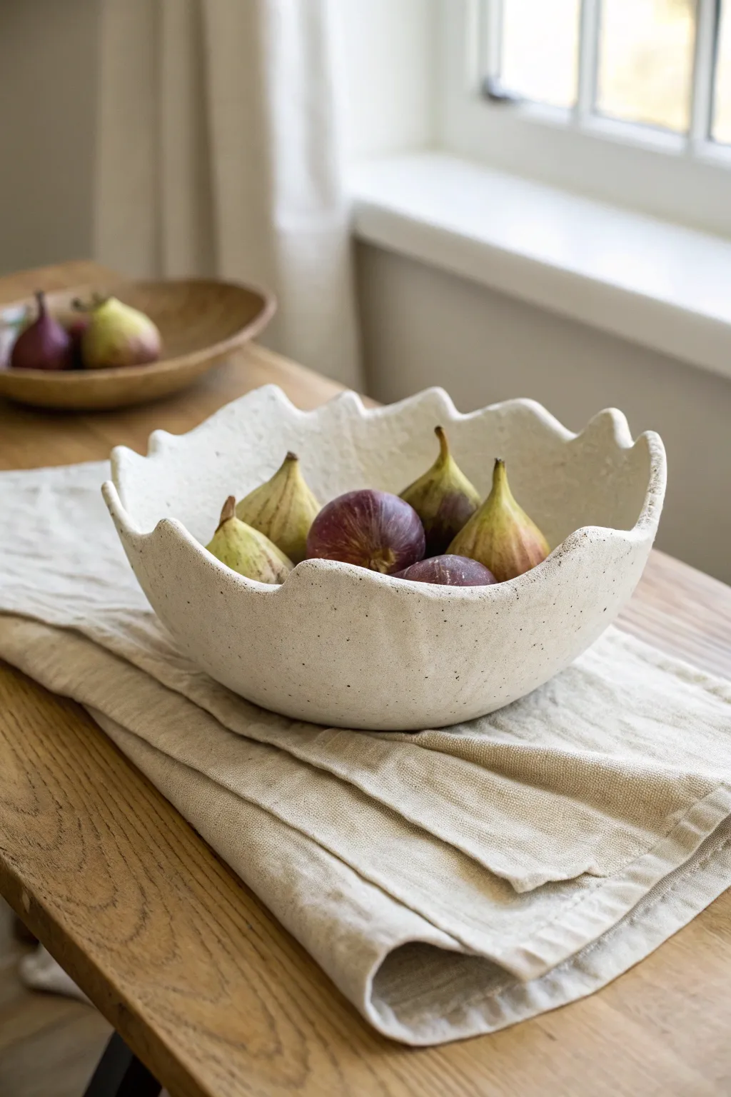 Wavy rim drape bowl centerpiece in speckled clay, a simple modern fruit bowl with boho warmth.