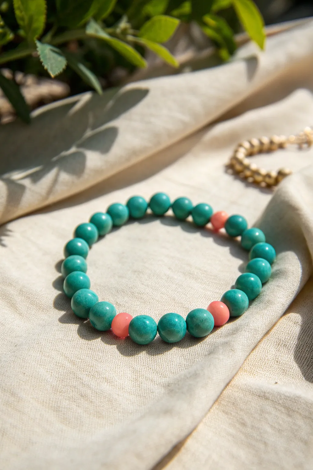 Teal clay beads with coral-pink accents for a fresh, summery minimalist bracelet.
