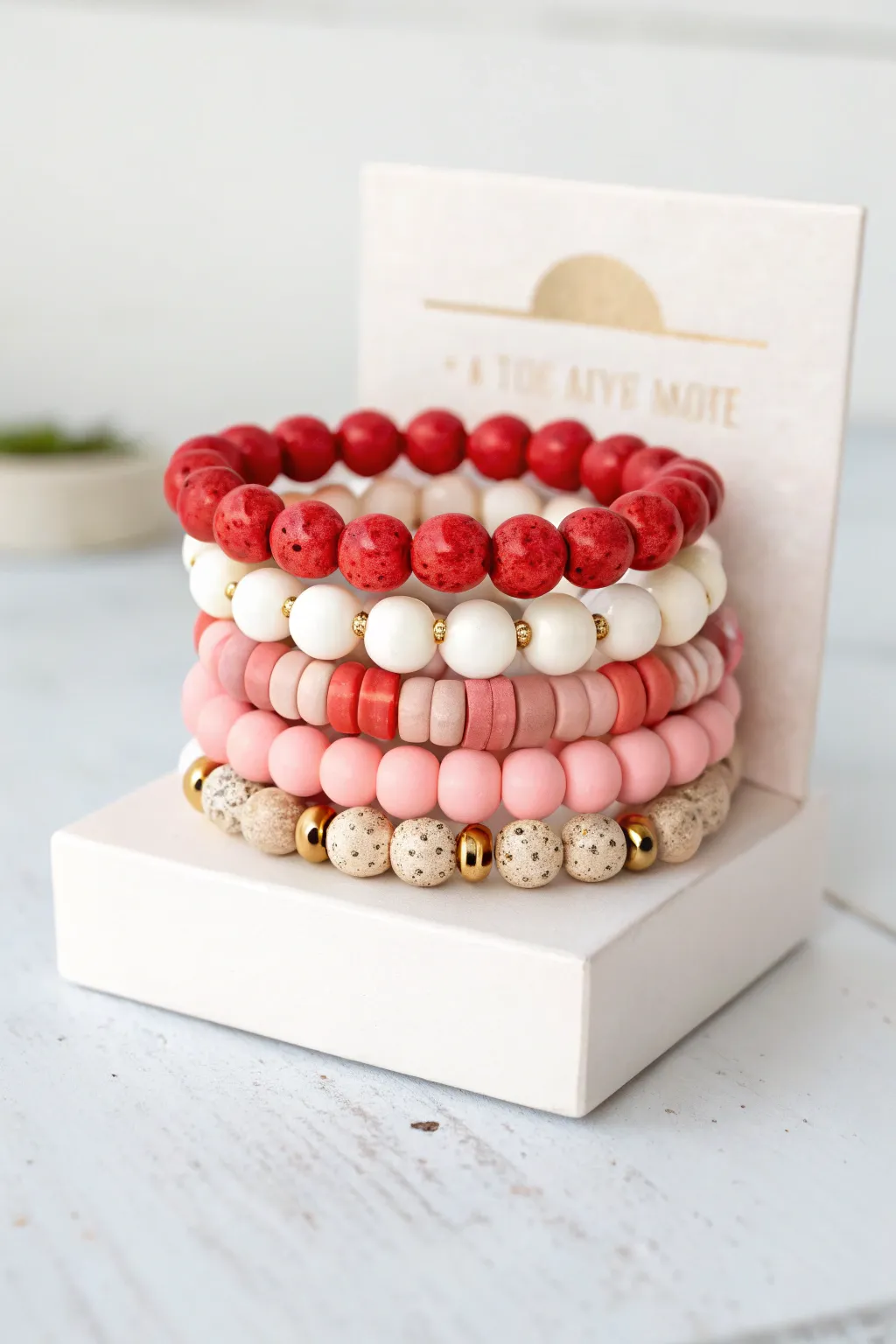 Coordinated Valentine bracelet stack in red, confetti, minimalist cubes, and a sweet heart focal bead