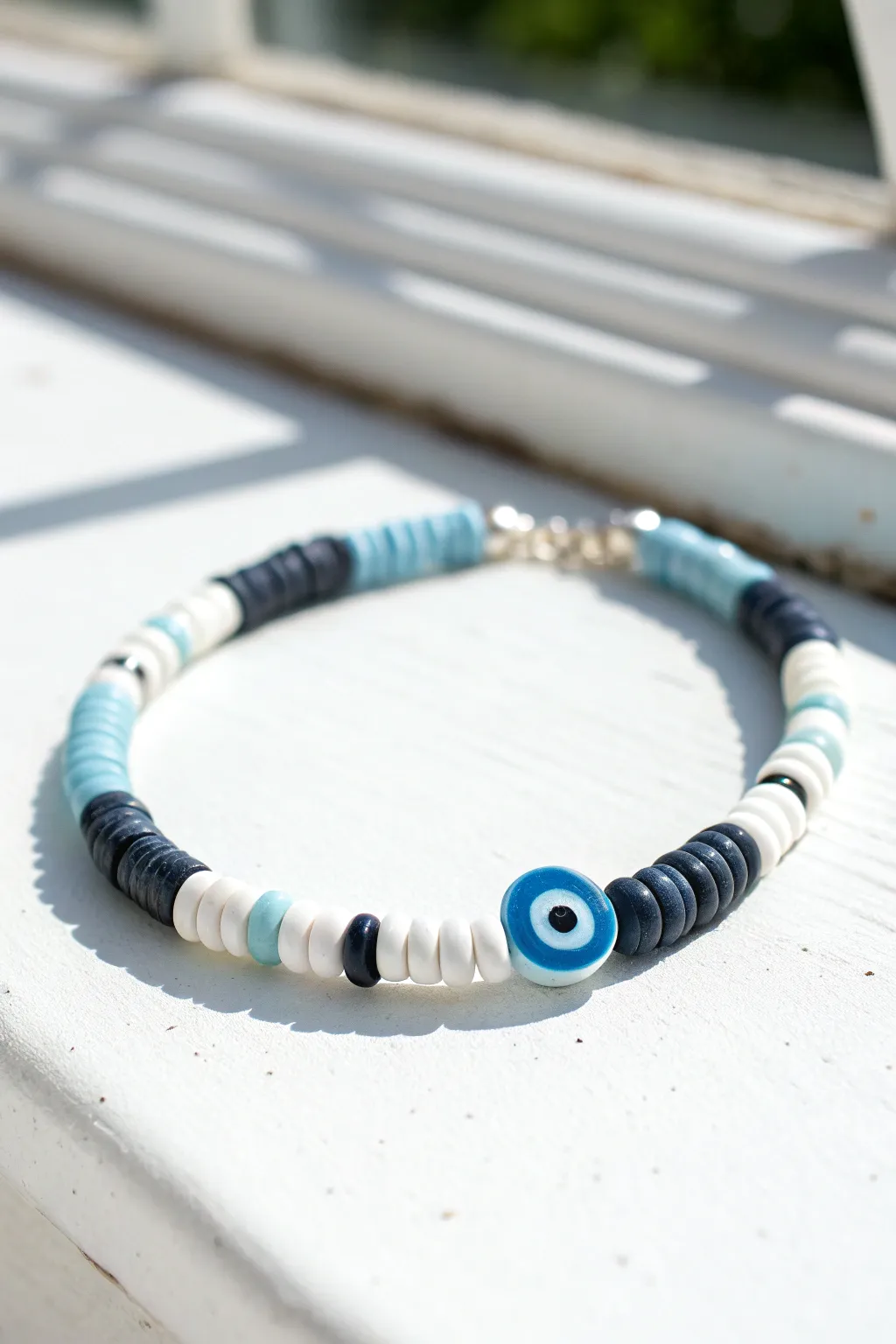 Minimal evil eye clay bead bracelet in navy, white and sky blue for a curated boho look.