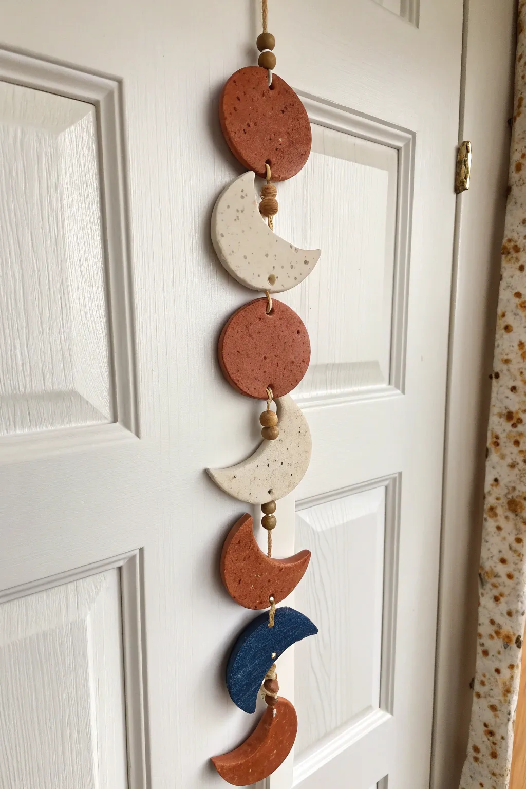 Air dry clay moon phase tiles in terracotta and indigo, a minimalist boho wall hanging