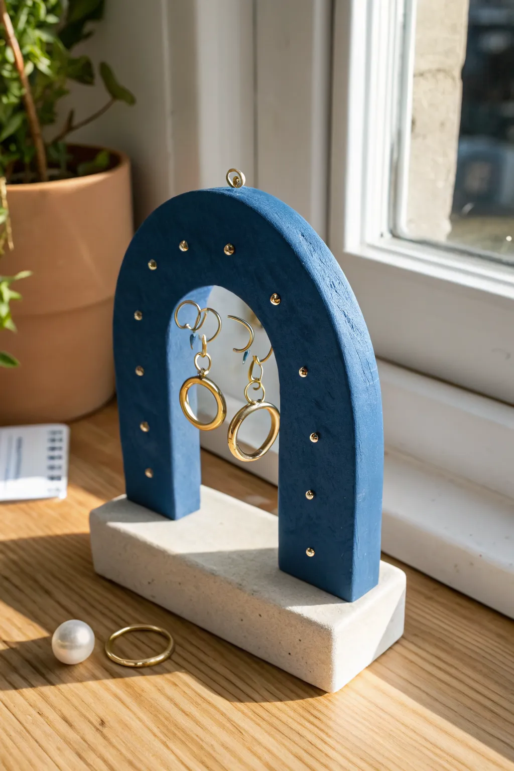 Minimalist air dry clay arch stand showcasing hoops and studs, perfect vanity organizer.