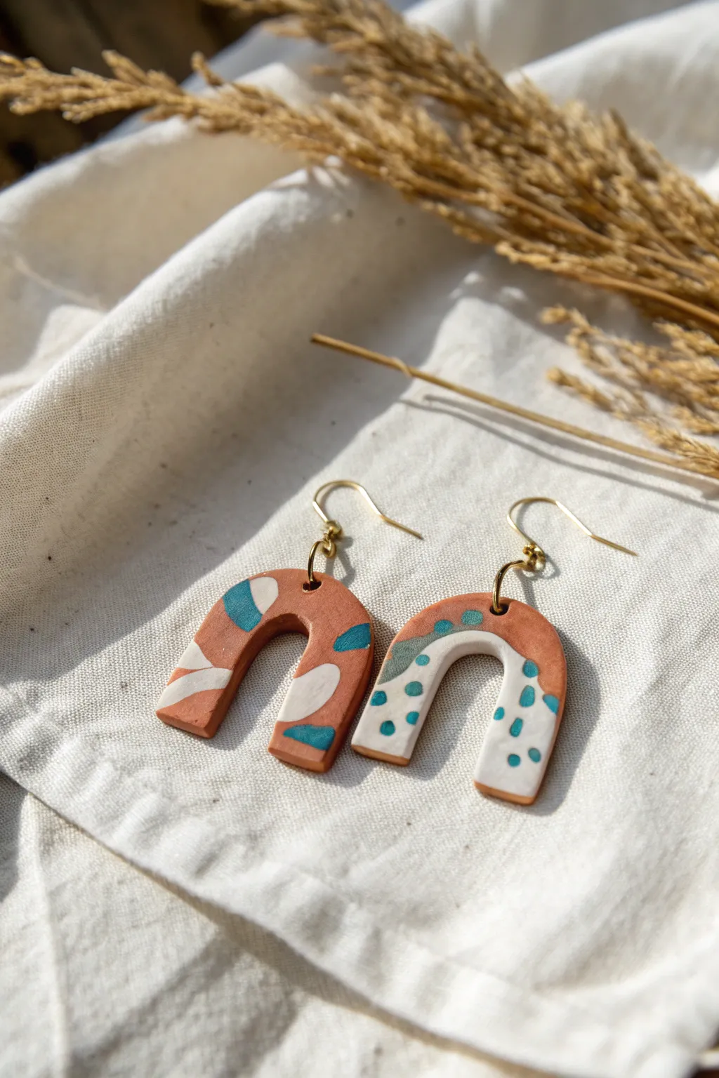 Minimalist air-dry clay arch earrings with subtle paint details on linen, easy DIY inspo.