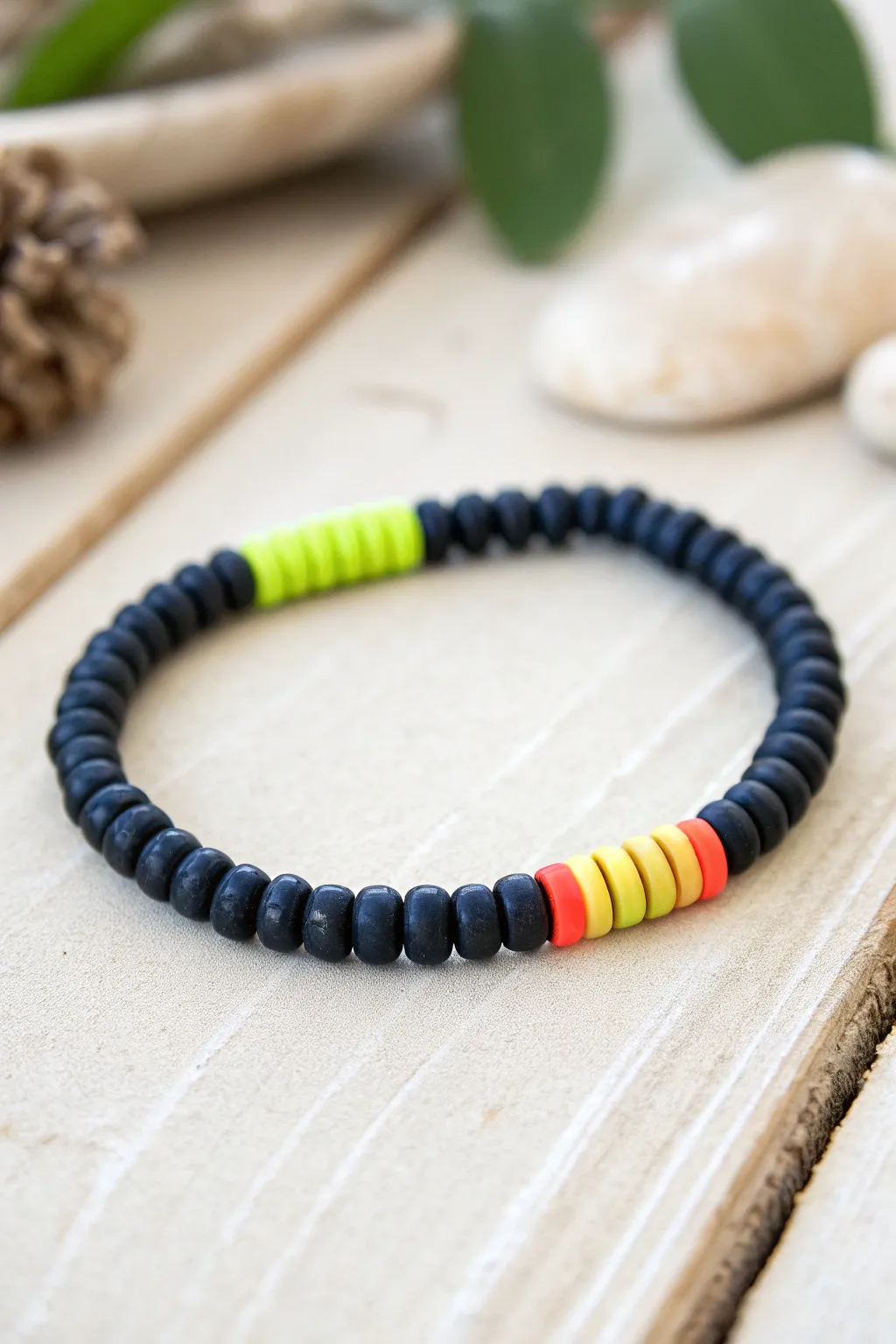 Matte black heishi bracelet with a centered neon stripe for a bold, sporty pop of color.