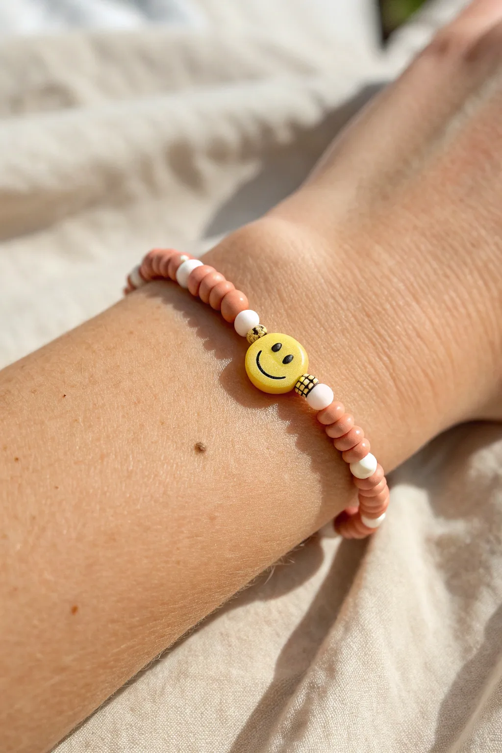 Matte clay discs meet pearly beads with a sunny smiley centerpiece for an easy DIY bracelet.