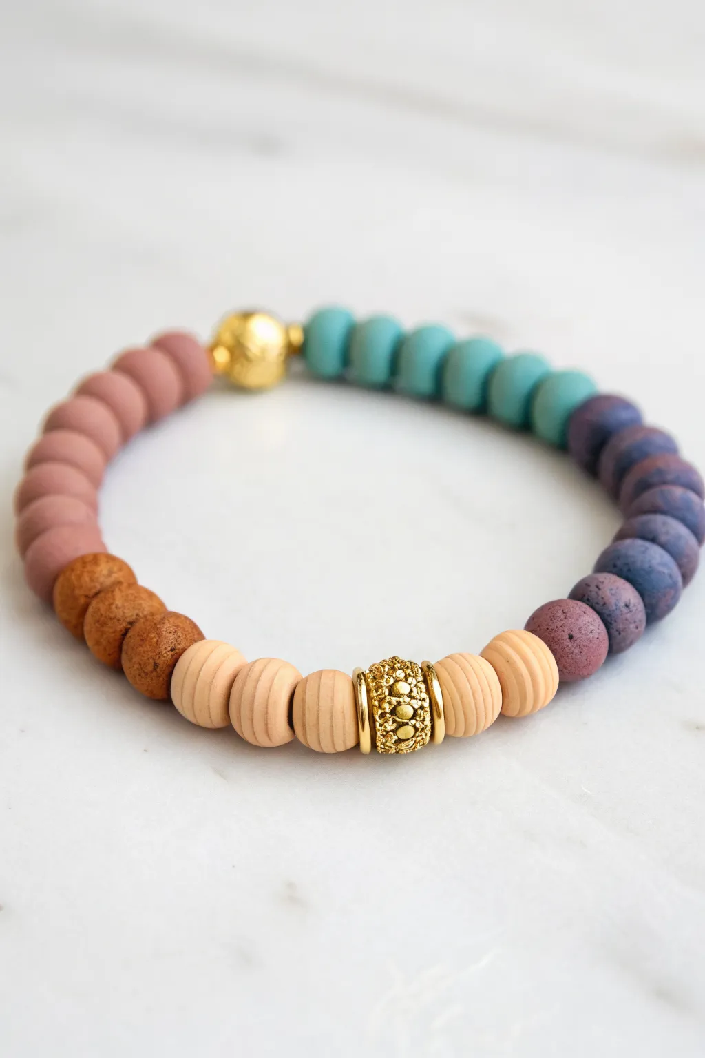 Warm and cool clay beads meet at a simple connector charm for a bold, balanced bracelet idea.