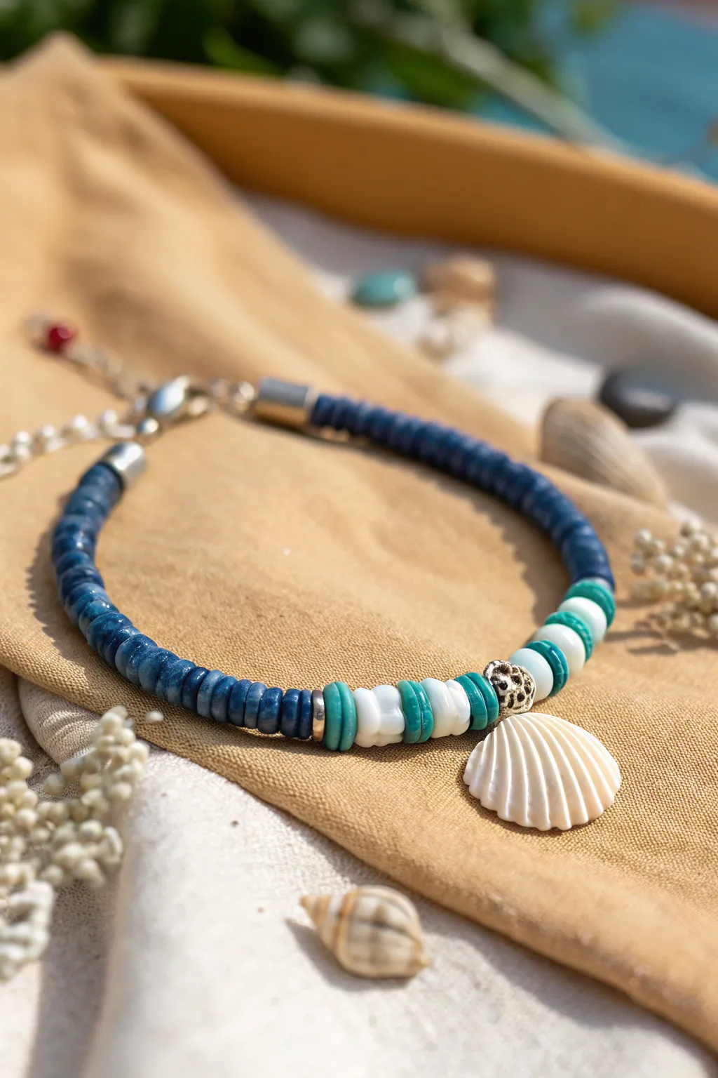 Beachy blues heishi bracelet with a delicate shell accent, styled on sand linen for calm boho vibes