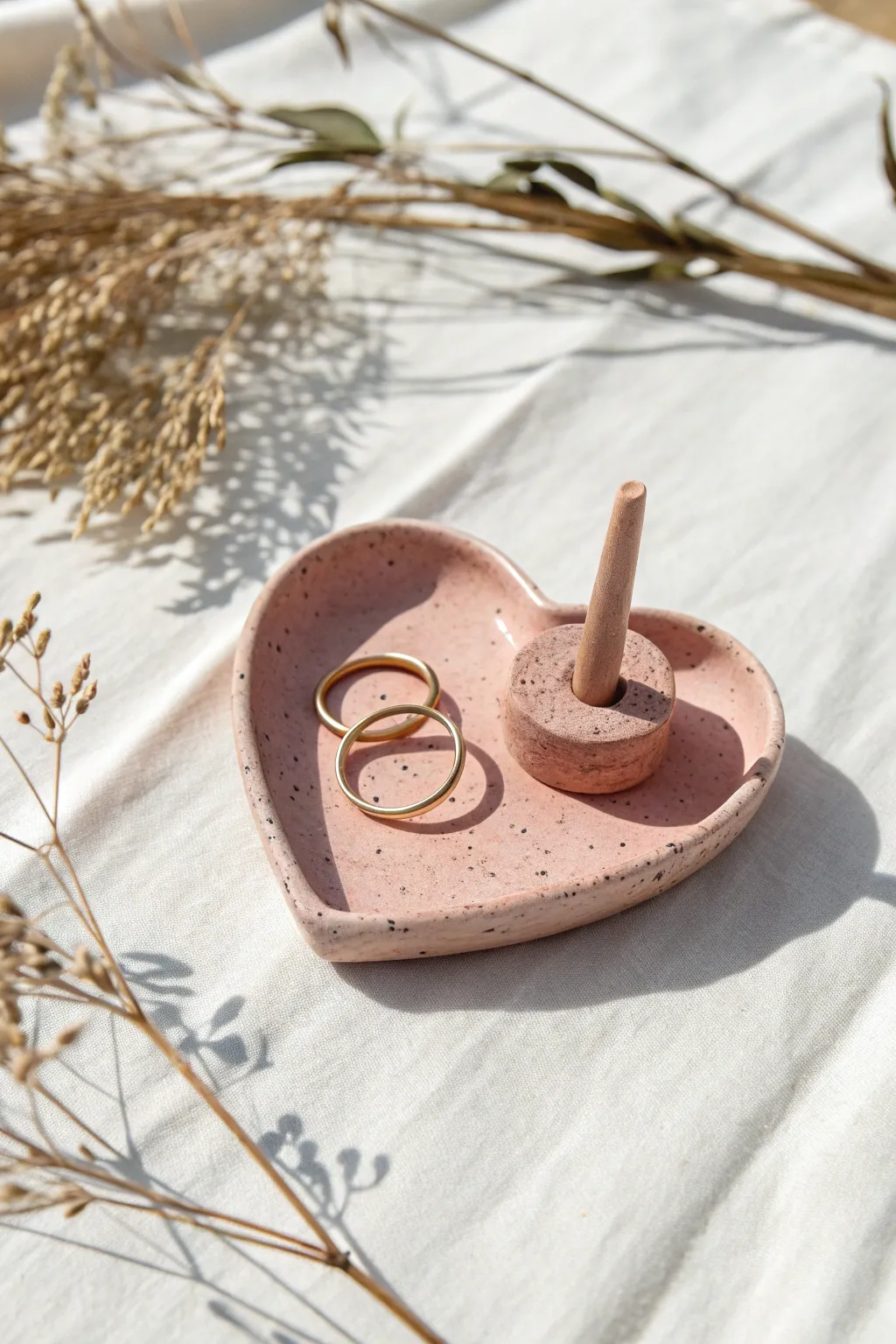 Minimal blush clay heart ring holder with stacked rings, Scandinavian boho vibe, bold contrast.