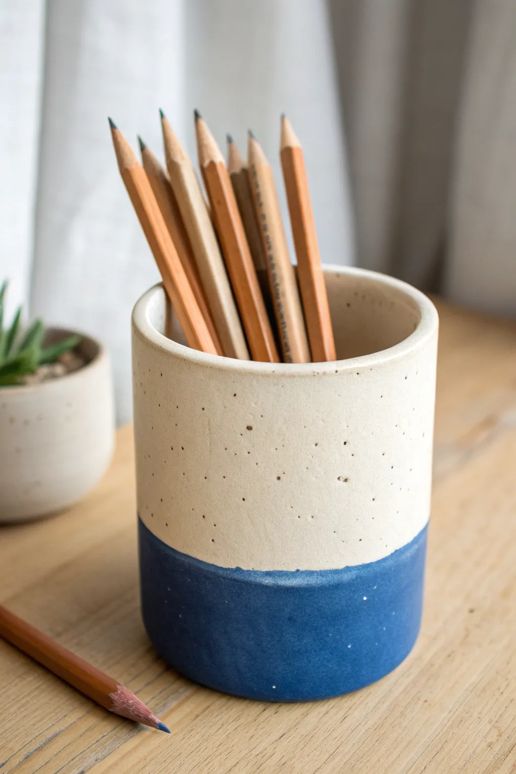 Clean dip-dyed clay pencil holder with bold two-tone color blocking for a minimalist desk.