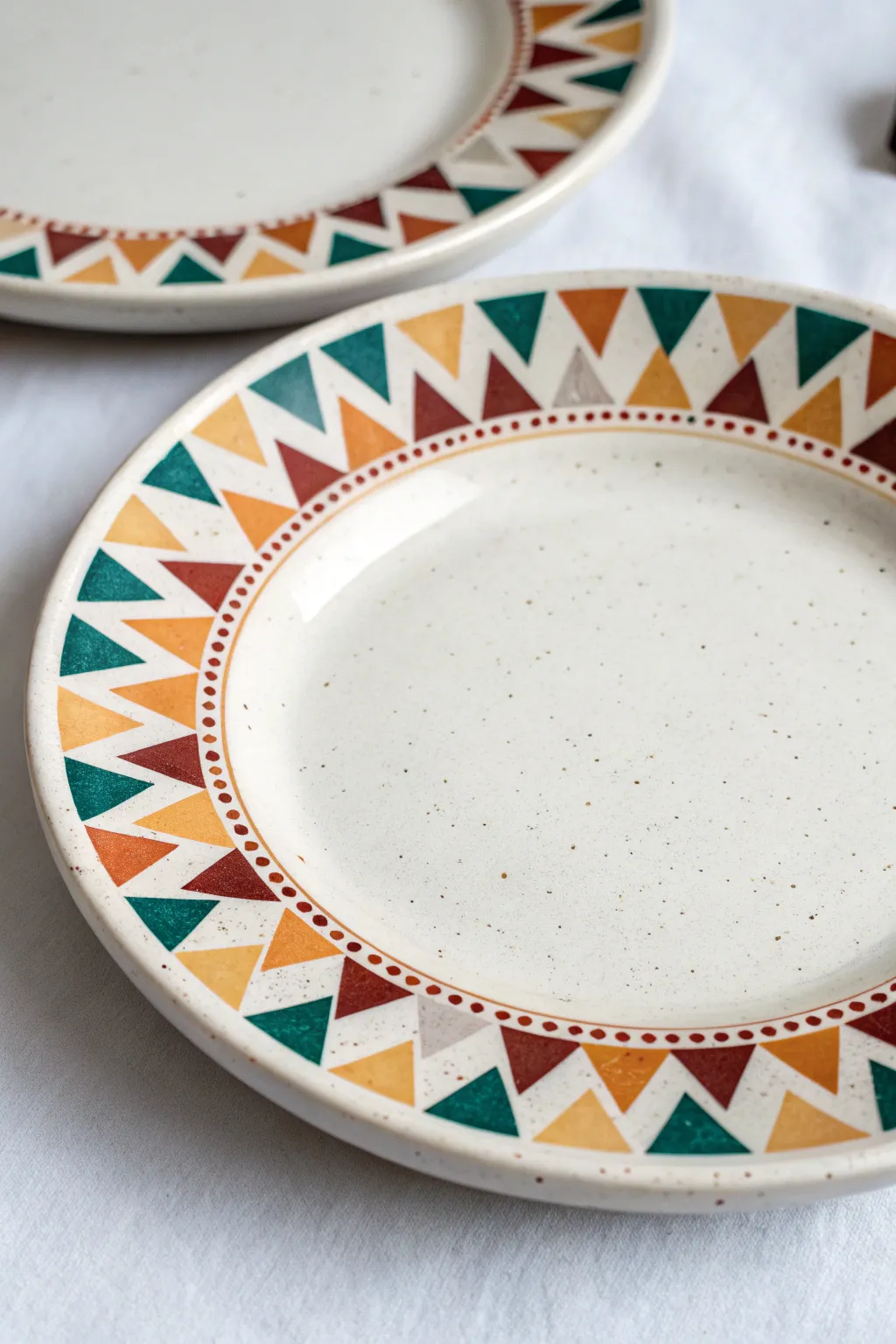 Geometric triangle mosaic plate in bold hues, minimalist Scandinavian style with boho warmth.
