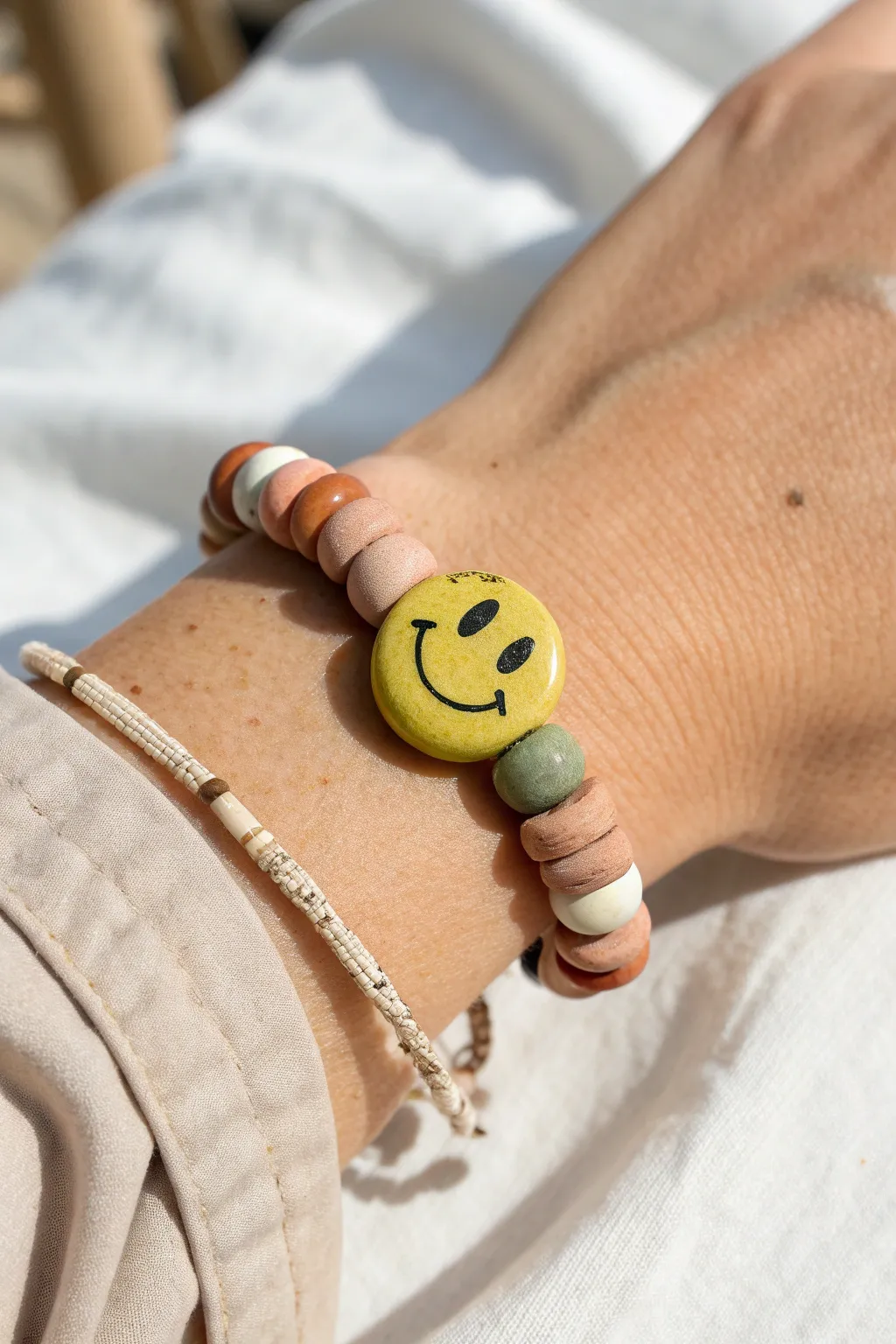 Bold smiley focal bead on a minimalist clay disc bracelet, perfect for playful DIY style.