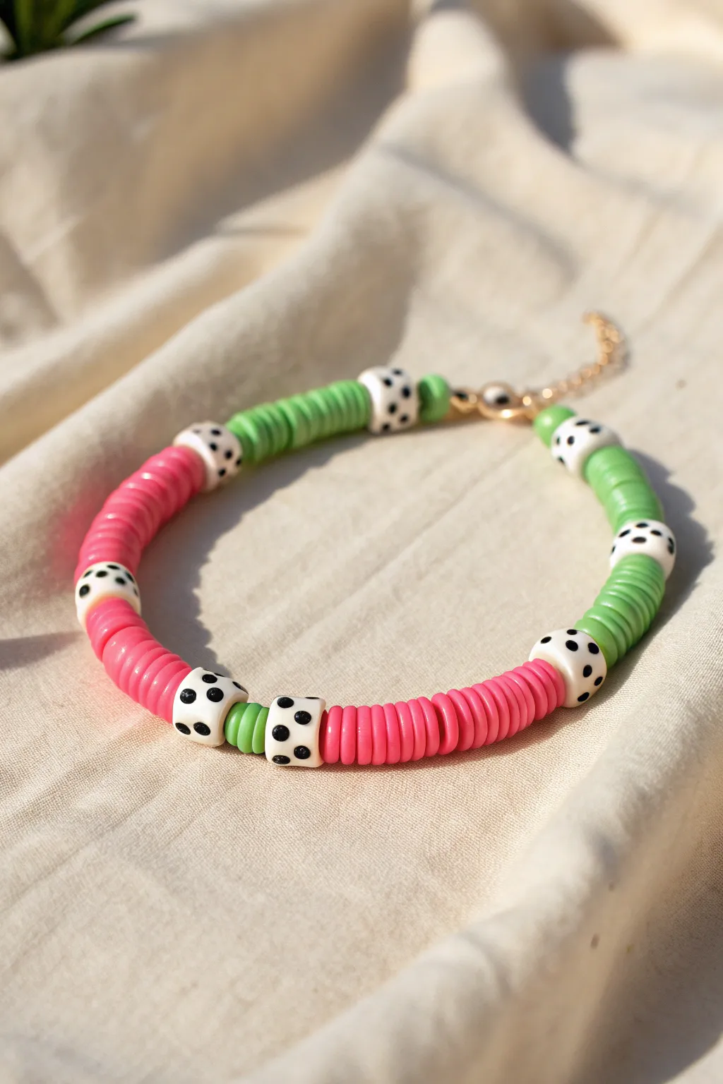 Watermelon heishi bead bracelet in sunny light, pink green white with tiny black seed accents