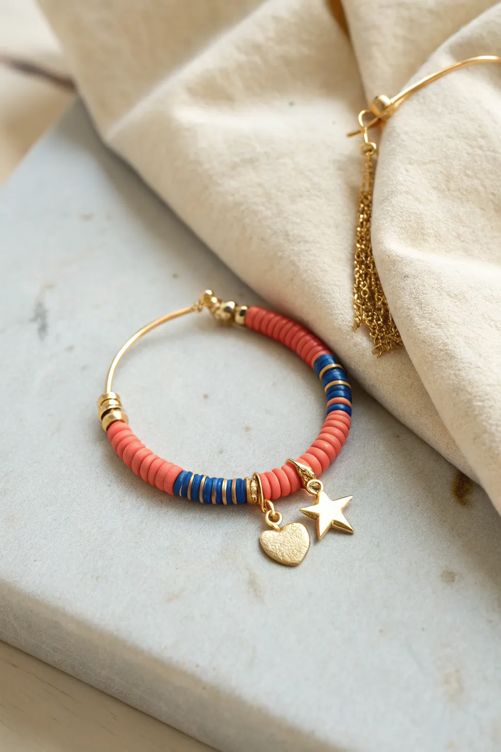 Tiny charm cluster + bold clay heishi hoops for a simple, cute DIY earring look.