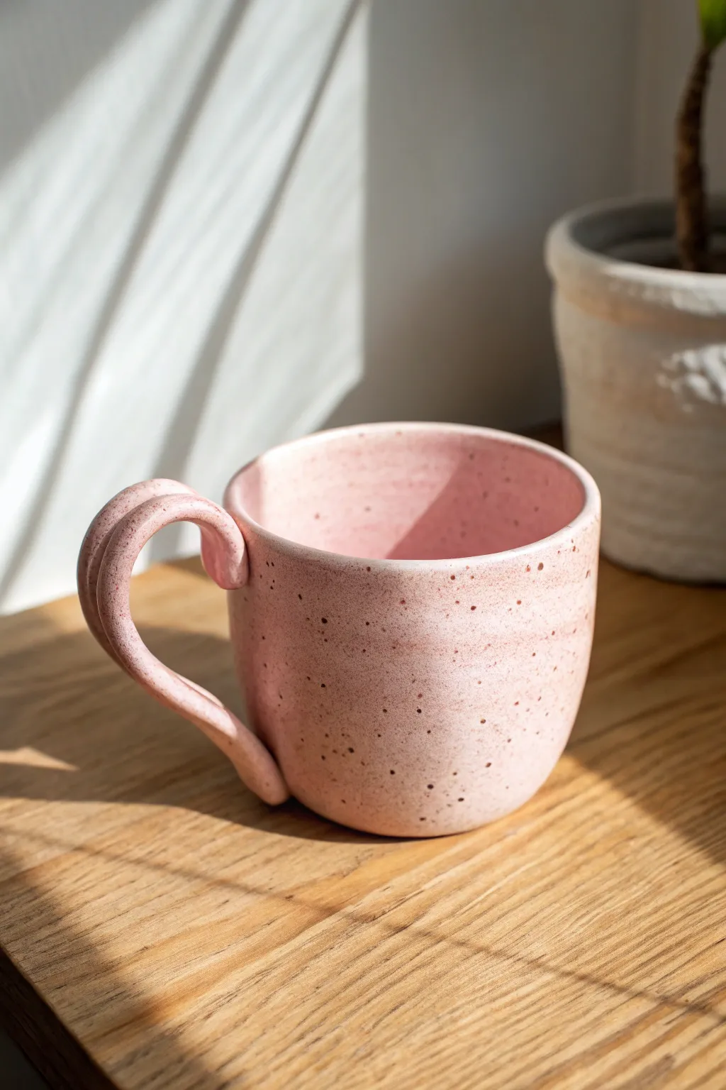 Oversized wavy-handle clay cup in soft blush pastel, minimalist yet playful and bold.