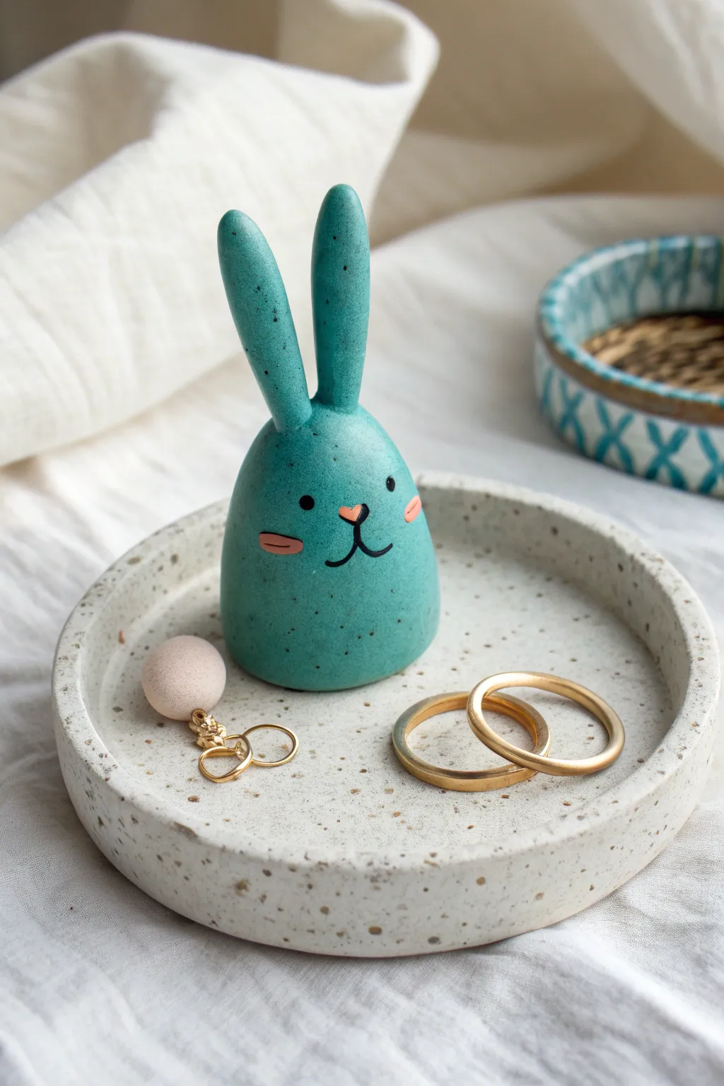 Sweet bunny ring holder in bold matte teal, a functional clay figure that looks perfect on a vanity.