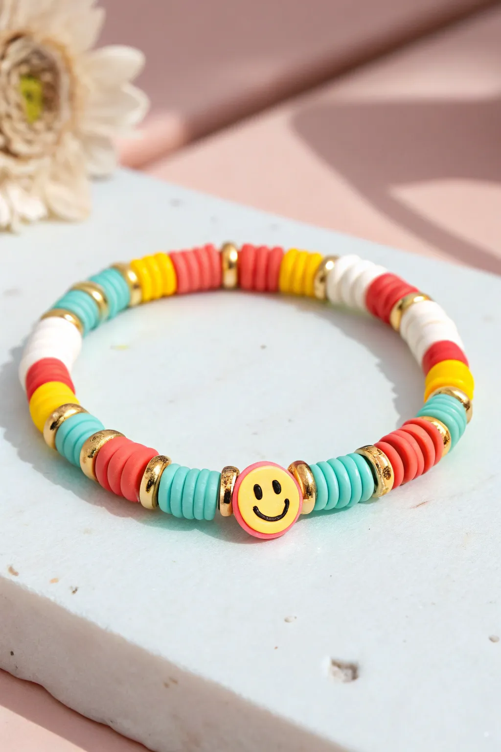 Bright heishi bracelet with a smiley pop centerpiece and gold spacers for cheerful minimal style.