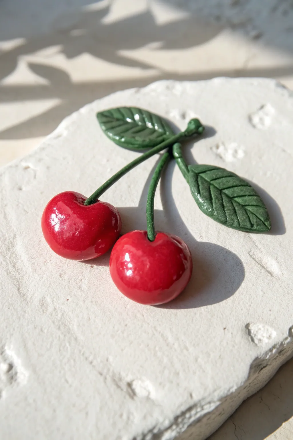 Bright cherry pair magnet in glossy red, simple stem, minimalist boho pottery vibe.