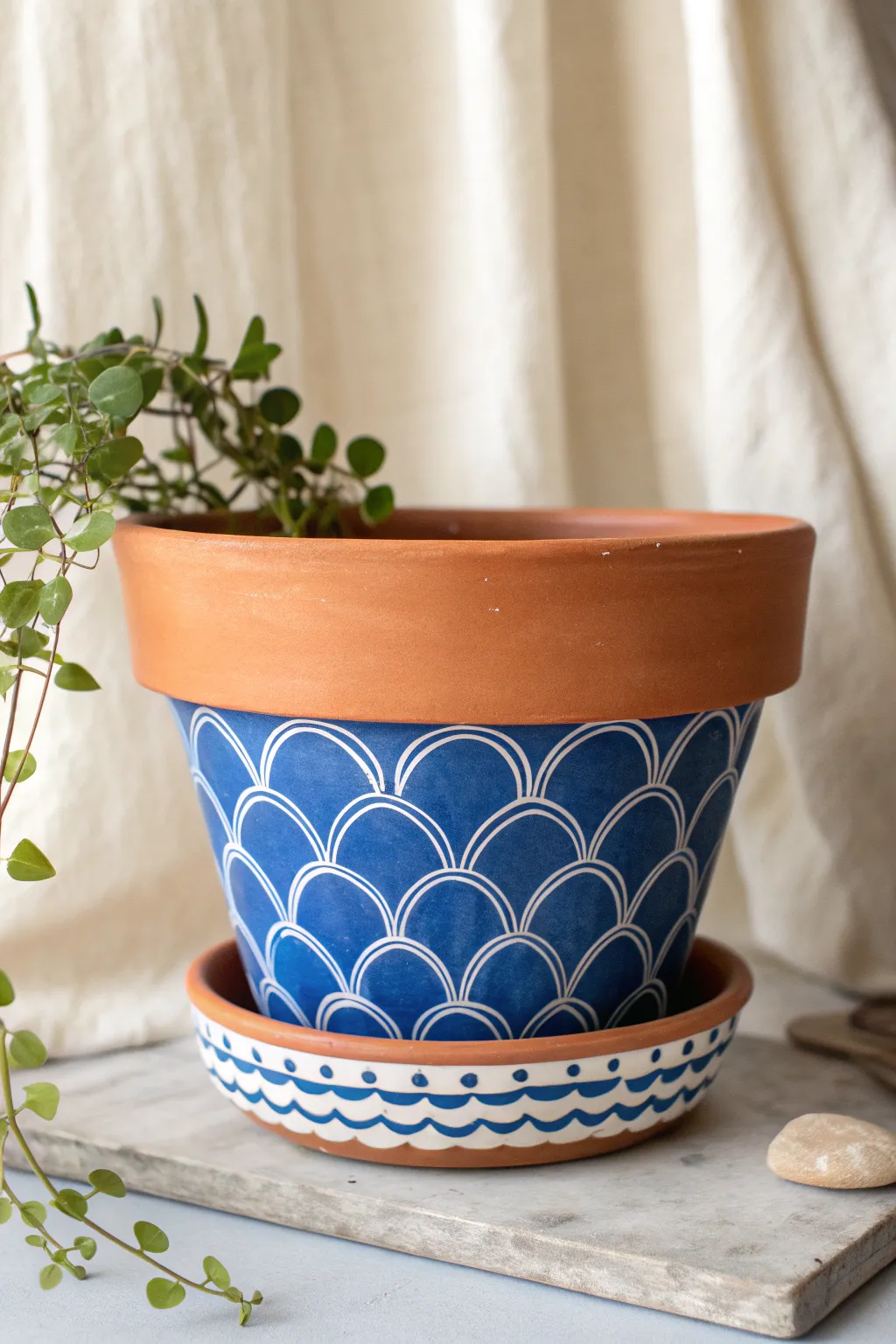 Folk-inspired petal scallops around the base add bold charm to a simple, minimalist flower pot.