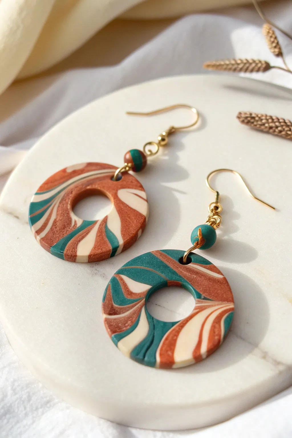 Marbled one-pull extruder earring, bold swirls and clean contrast on white for easy inspiration.