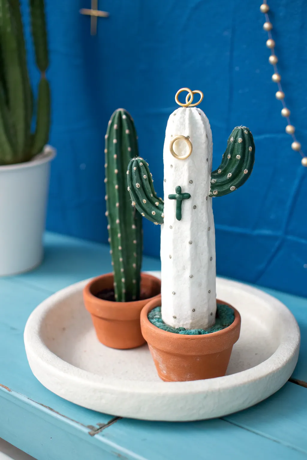 Minimal white cactus ring holder with preppy plus-sign spines and stacked rings on a tray