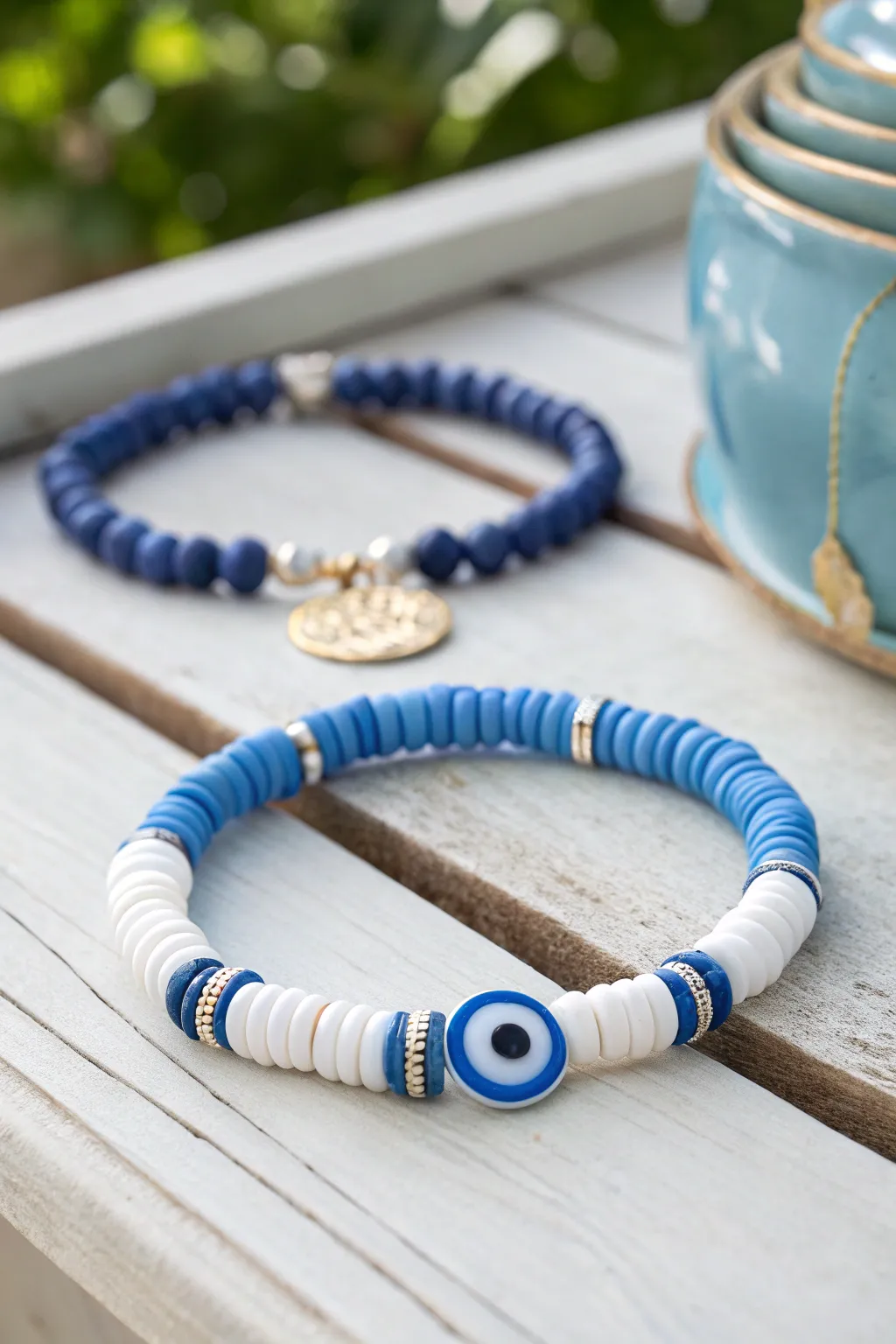 Preppy coastal vibes with blue and white clay discs and a bold evil eye centerpiece.