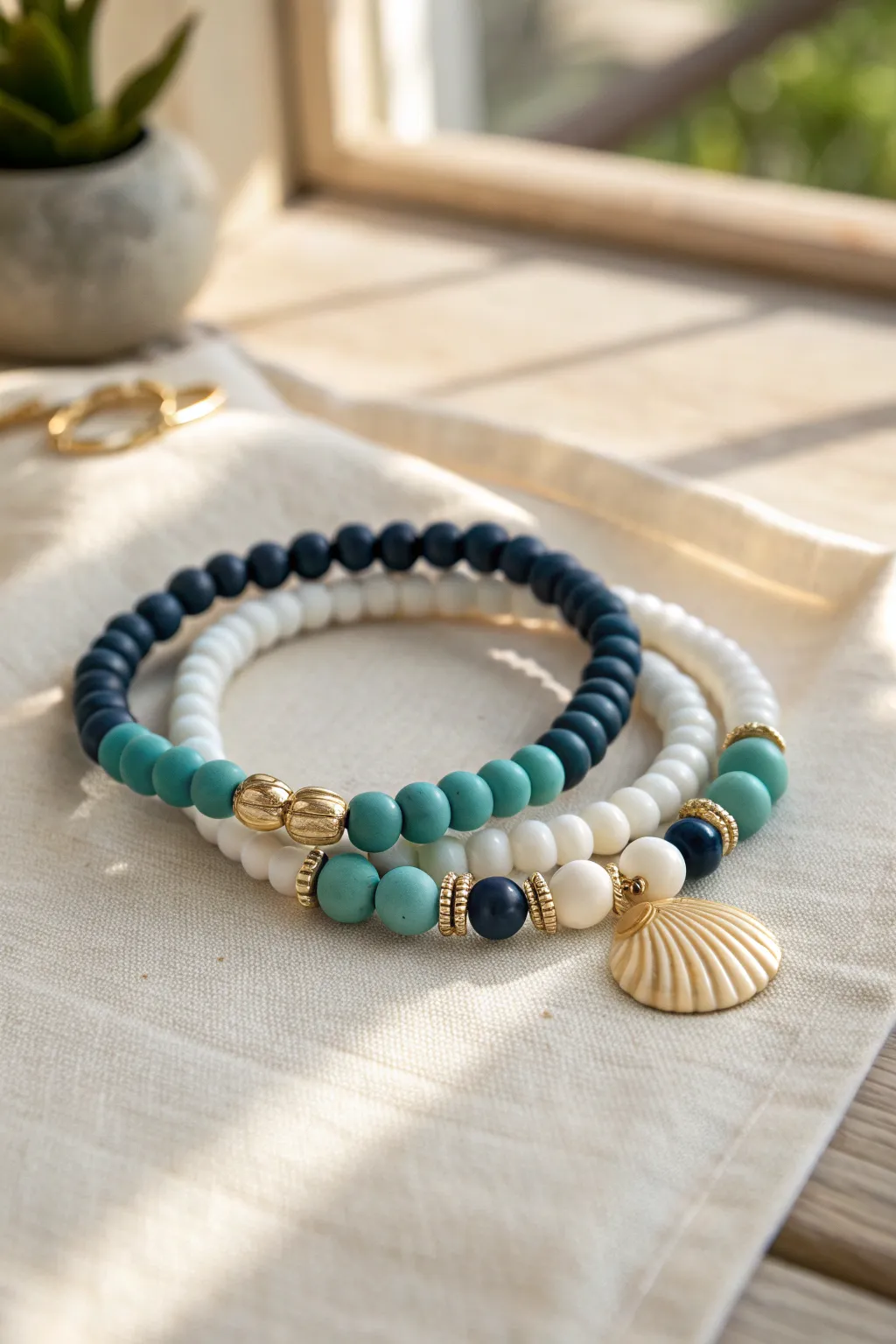 Coastal preppy clay bead stack with a shell charm, ocean hues, crisp white, and gold accents.