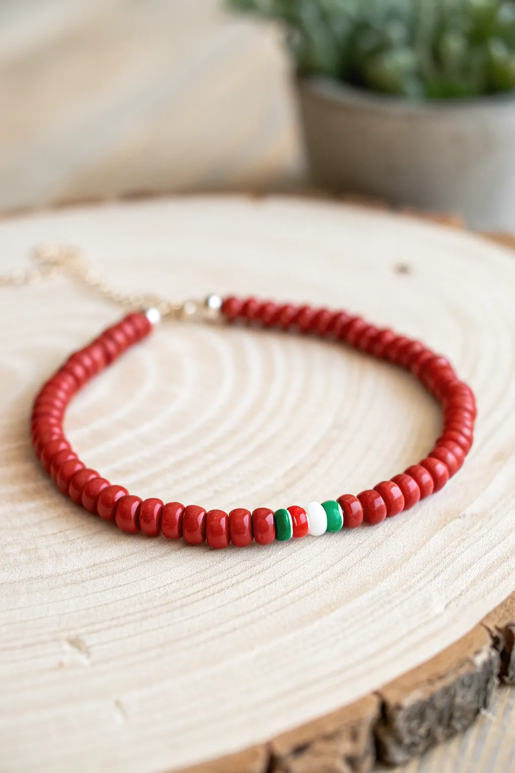 Festive red heishi bracelet with tiny green and white pops for a clean holiday look.