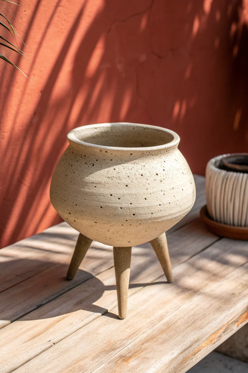 Bulbous tripod pot with sculpted legs mirroring the belly, simple, balanced, and modern.