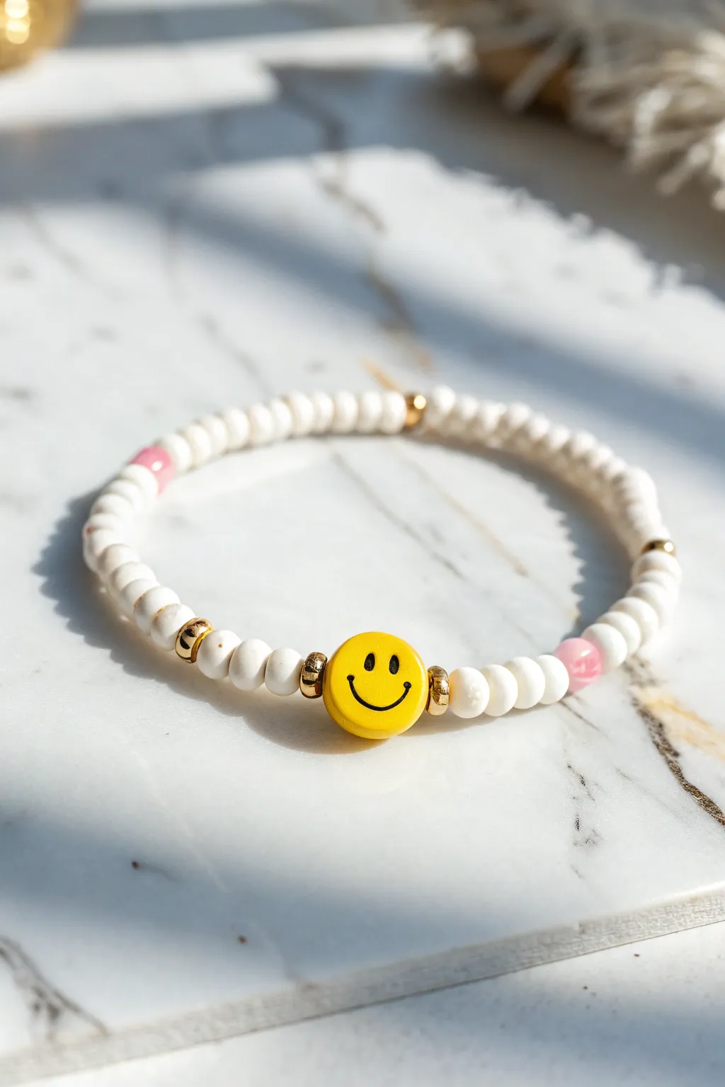 Cheerful heishi clay bracelet with a bold smiley bead, crisp white and blush accents.