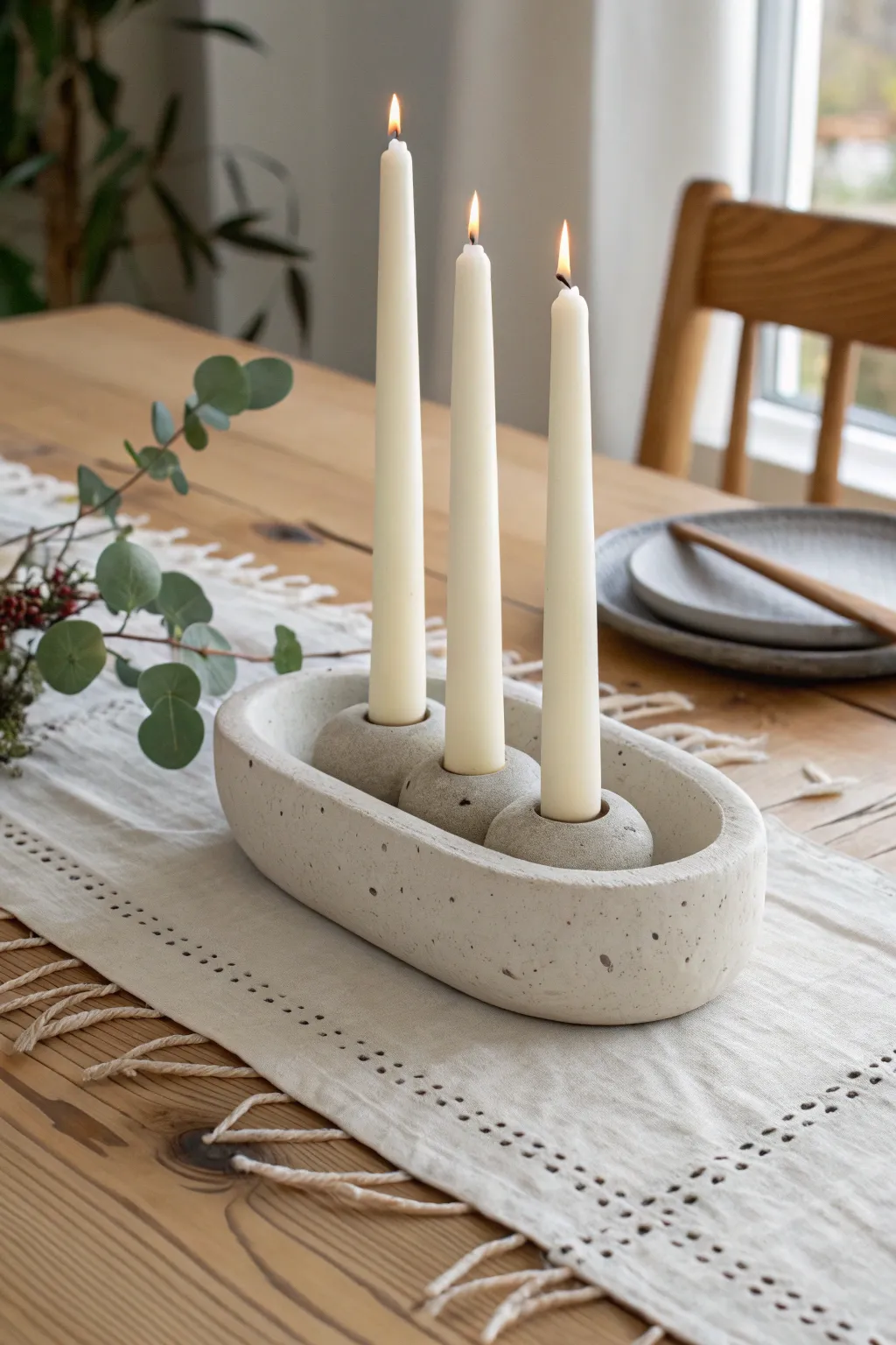 Minimal triple taper centerpiece in air dry clay, softly styled with linen and fresh greenery