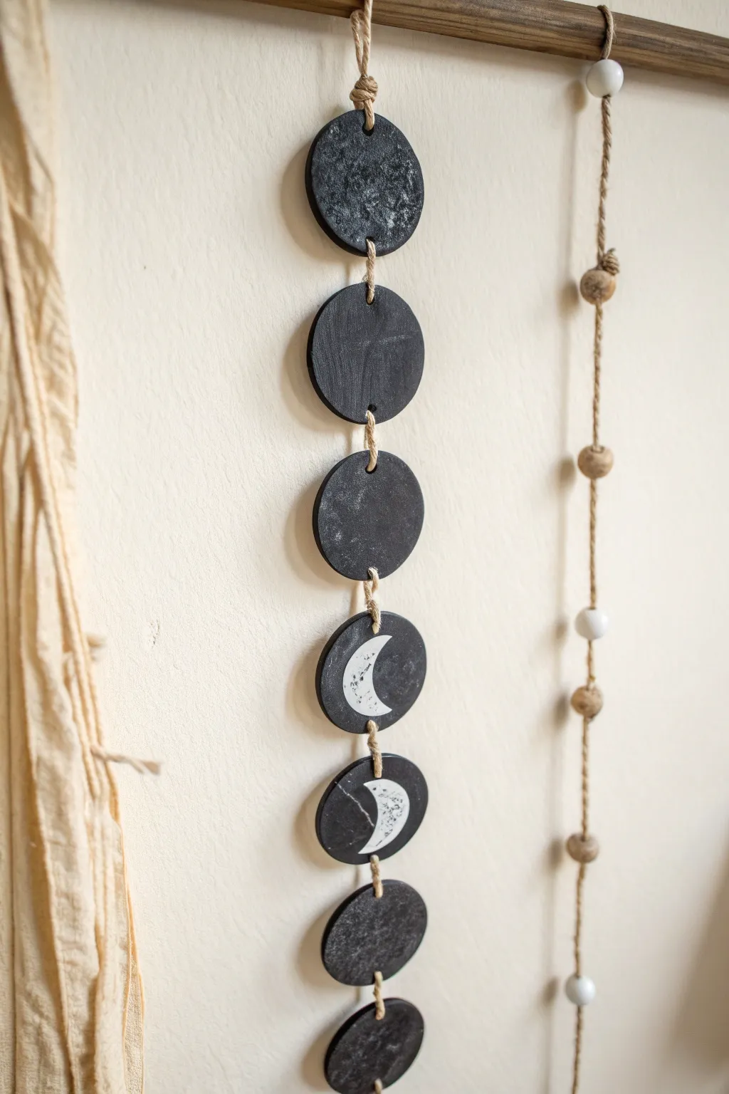Minimal black clay moon phases with soft white edges, a calm boho accent for any wall