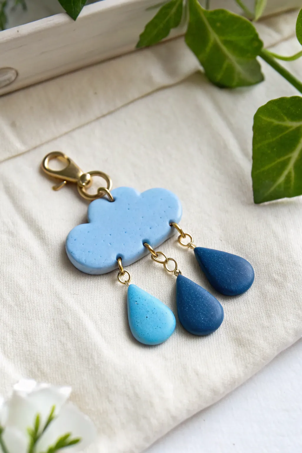 Soft blue cloud charm with deep blue raindrops, minimalist and boho, bright and calming.
