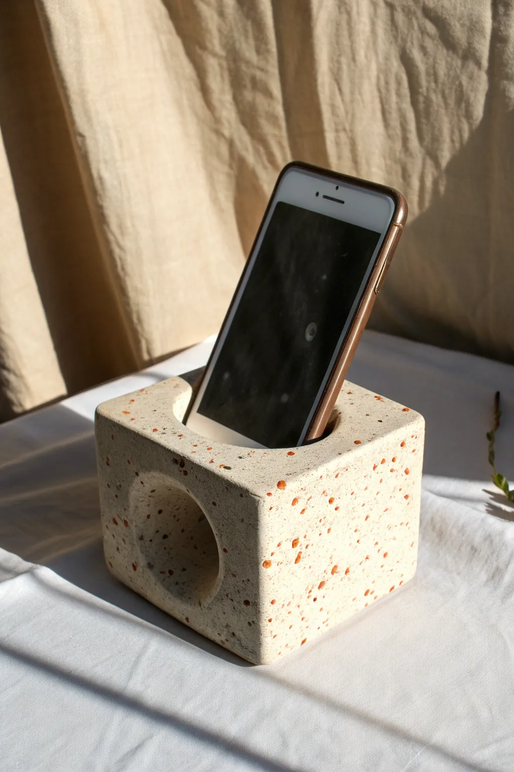Minimal terrazzo-look ceramic amplifier block, a chic way to boost sound without power.