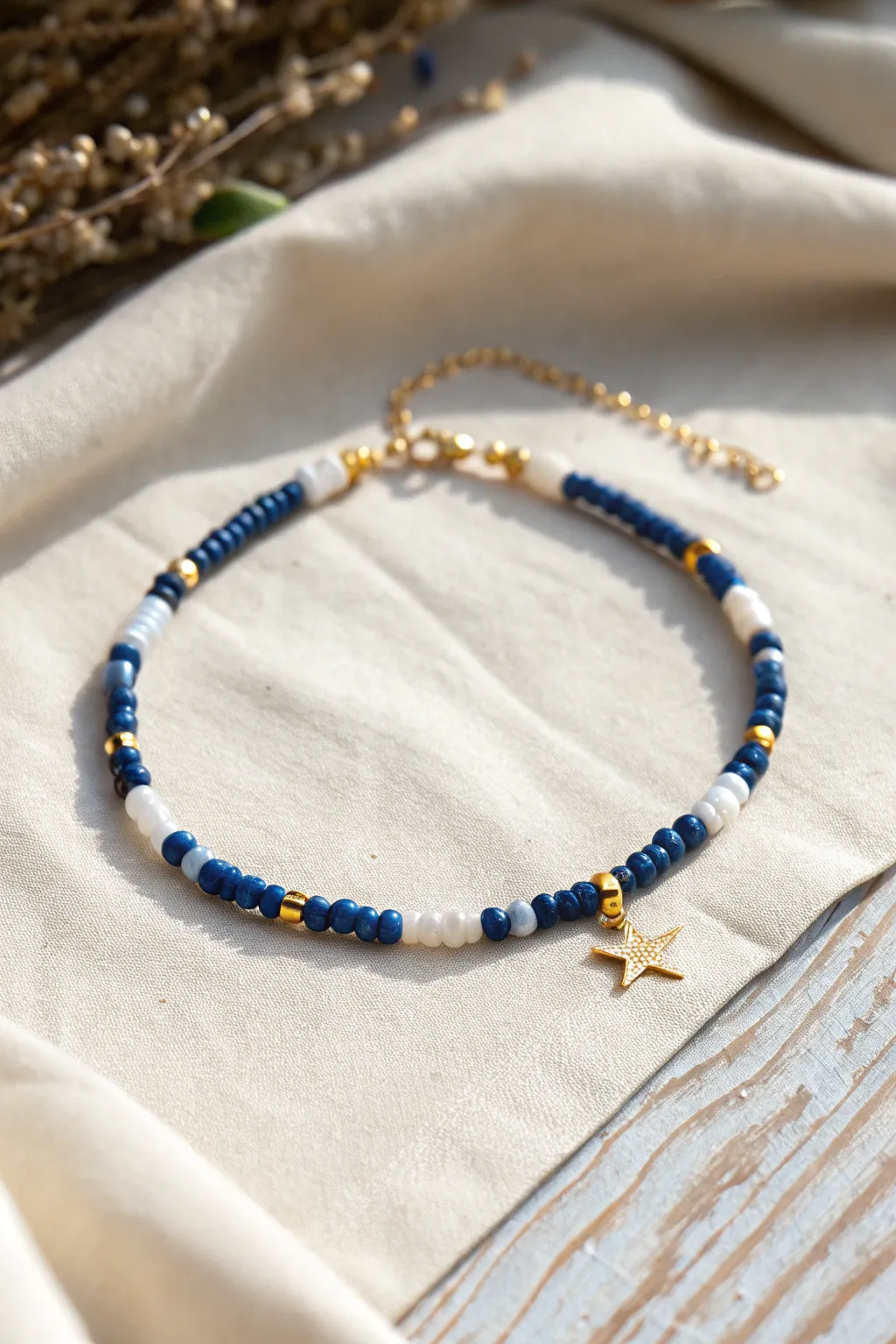Night-sky heishi bead anklet with a tiny star charm, bold blues in bright sunlight