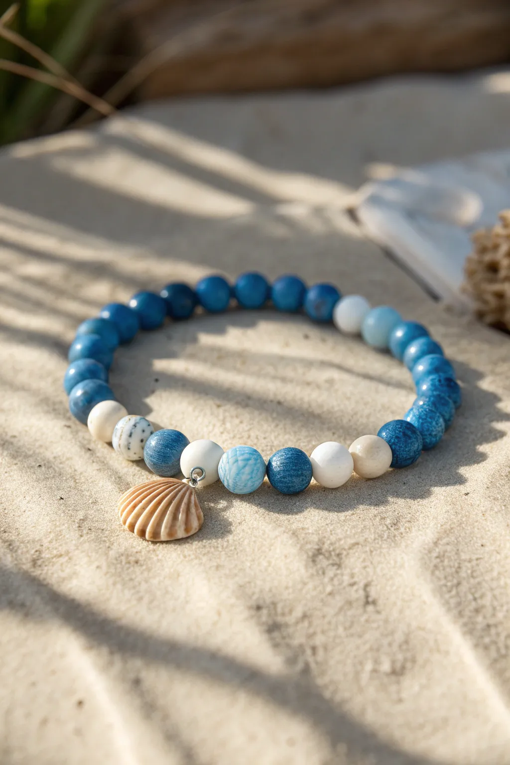 Blue clay beads and a tiny shell charm for an easy beach bracelet with shoreline whites.