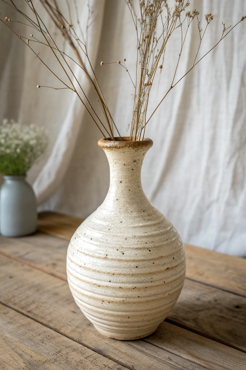 A gently leaning coil vase with soft lines and dried stems for an effortless modern-boho look
