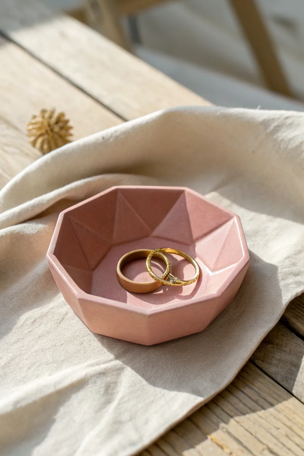 Minimal faceted clay jewelry dish in matte blush, styled with rings for modern boho calm.