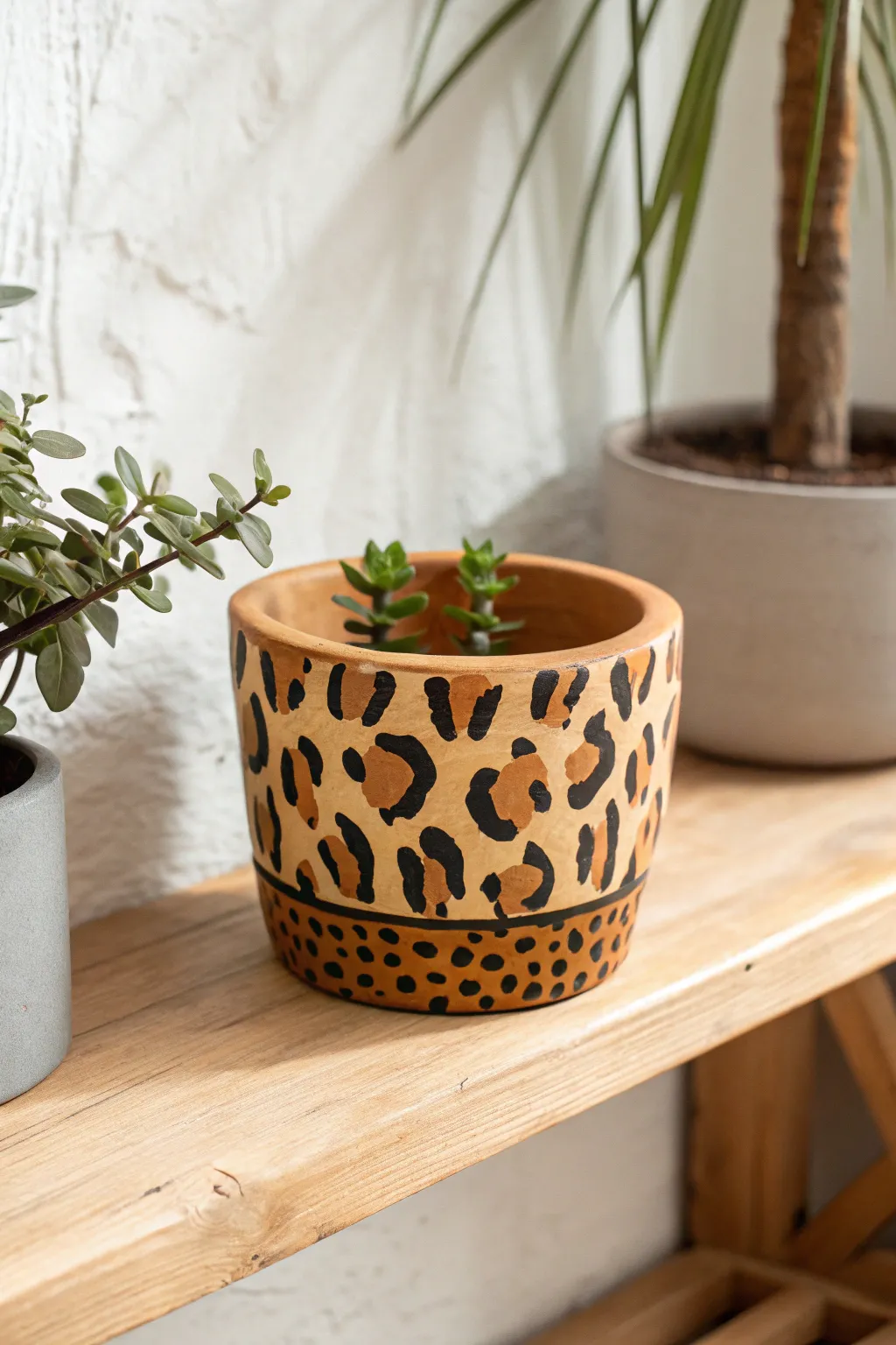 Playful animal-print planter on a minimalist shelf for an easy bold clay painting idea.