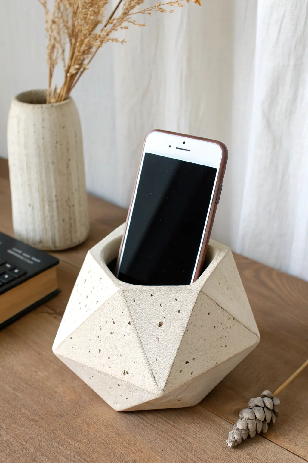 Faceted clay phone amplifier with a clean slot and bold horn opening in a calm Scandi setting.