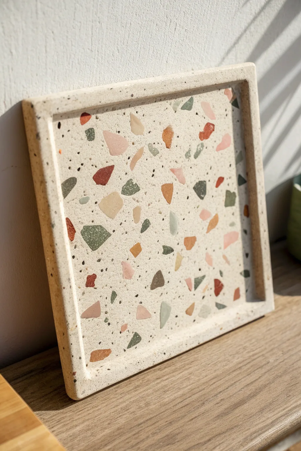 Terrazzo chip inlay clay plaque with clean edges and soft, sunlit minimalist styling