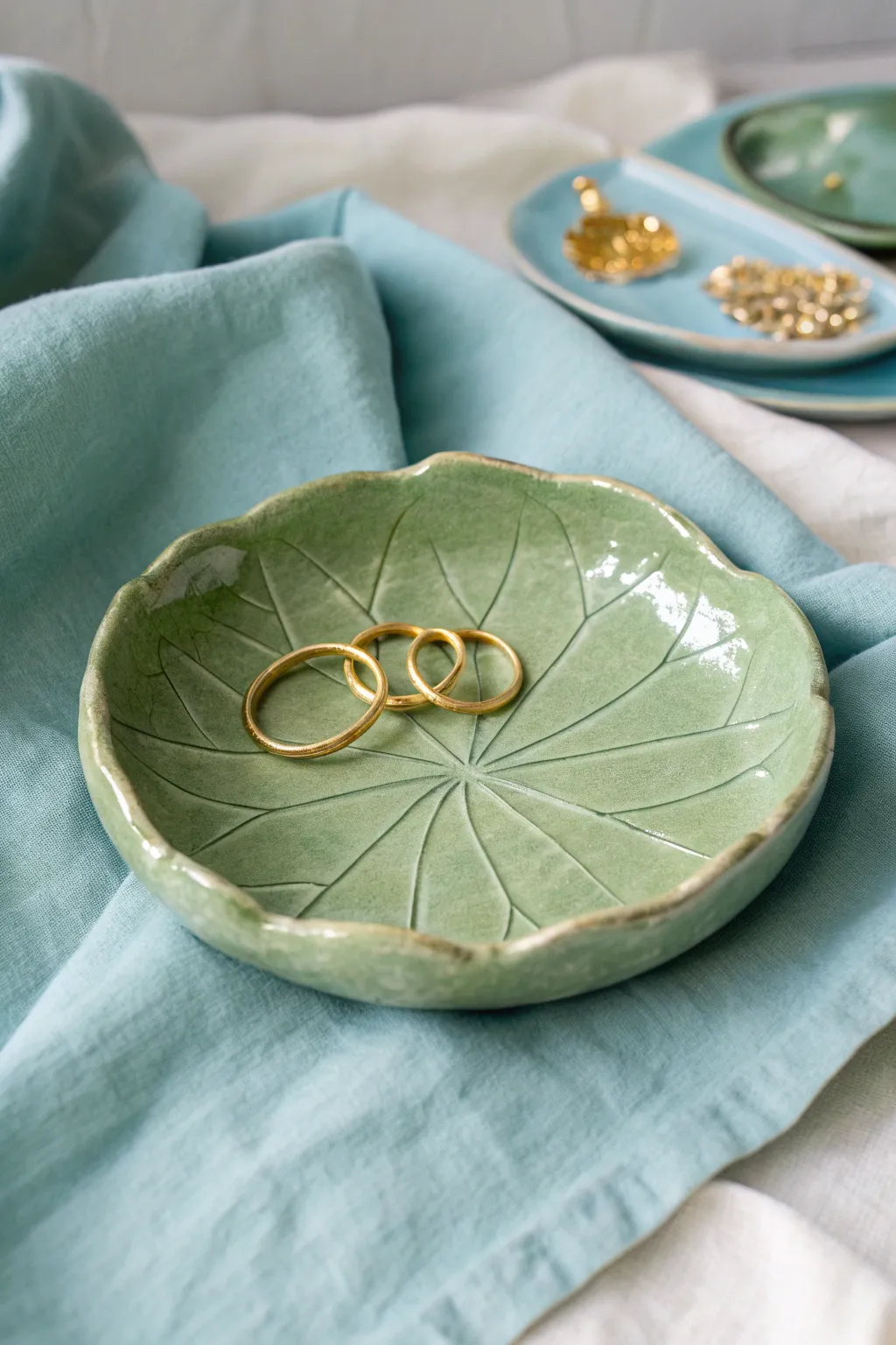 Pond-inspired lily pad tray in soft green, styled simply with rings and watery linen.